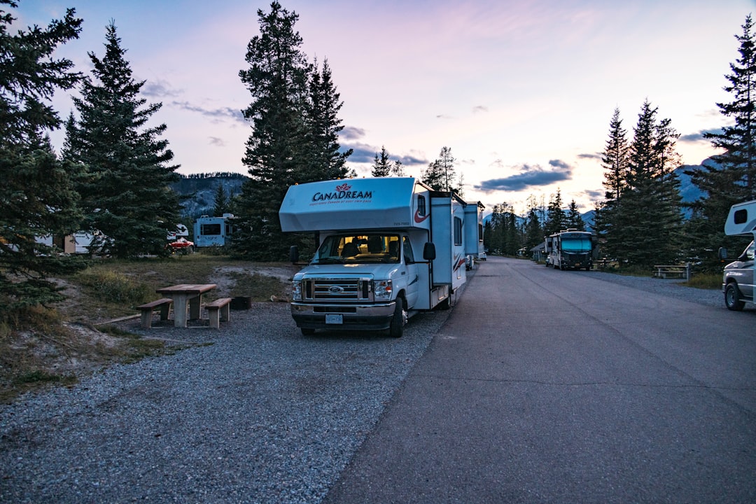 A motorhome parked in a campground at twilight.
